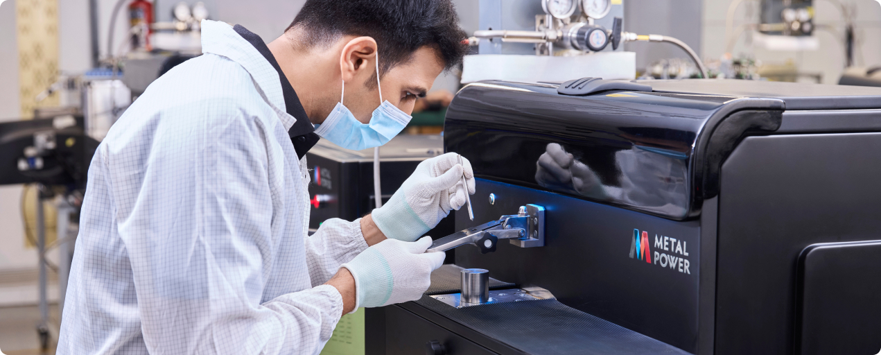 Technician analyzing metal sample using a Metal Power Optical Emission Spectrometer (OES)
